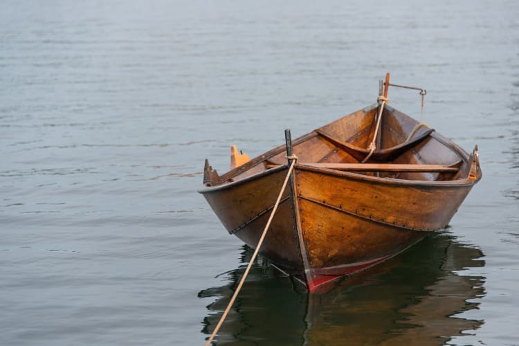 A wooden rowing boat out on a still body of water