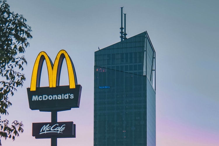A sunset shot of a McDonald's sign next to a building