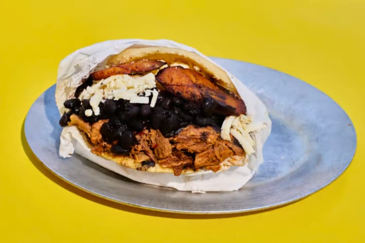 Arepa filled with shredded beef, black beans, plantains and cheese