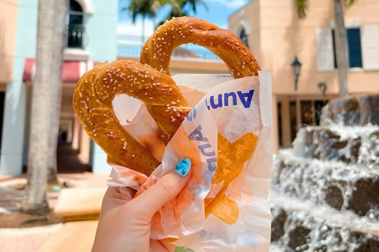 A hand holding a pretzel, which is free birthday food from Auntie Anne’s