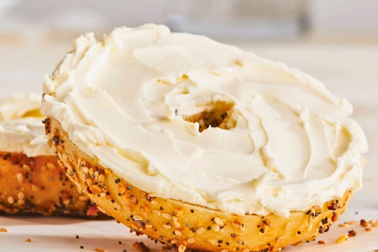 A seeded bagel with cream cheese.
