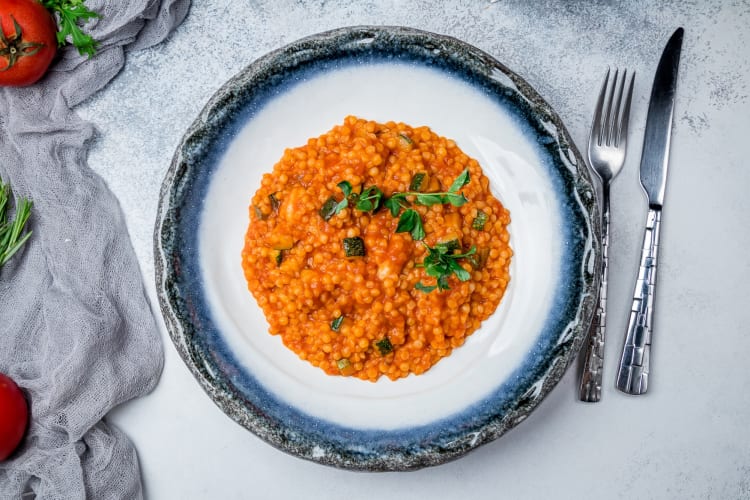 Fregola pasta with red sauce and vegetables