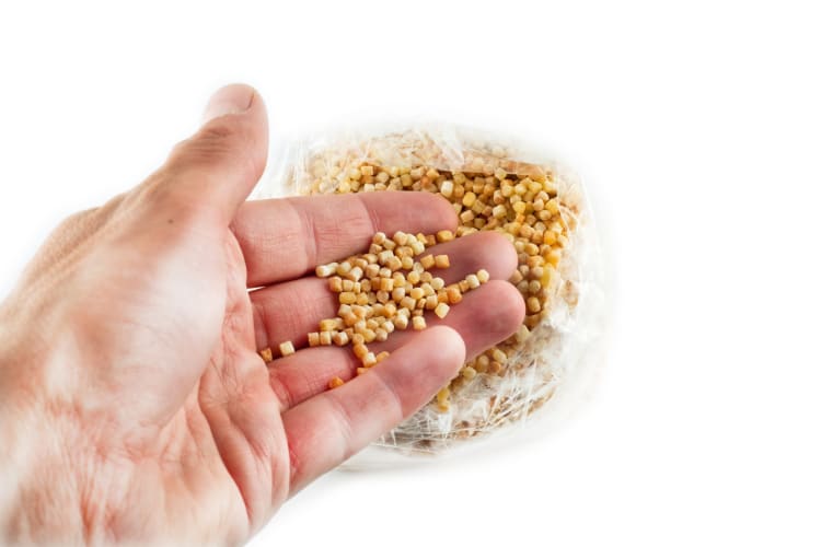 Man picking fregola out of a bag