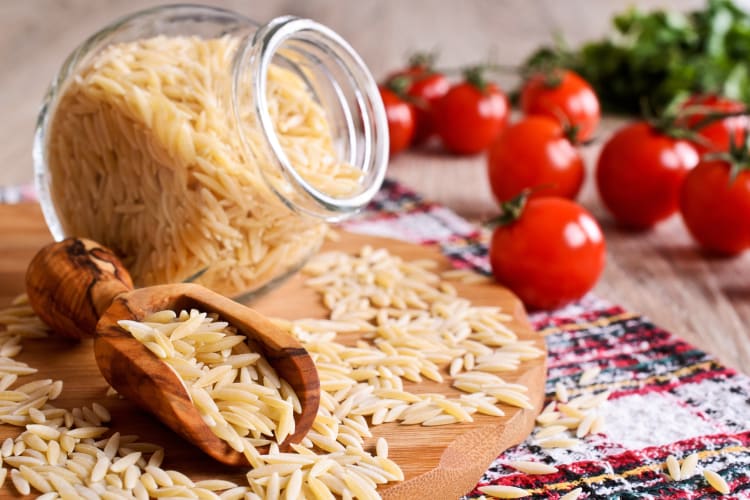 Orzo alongside whole tomatoes