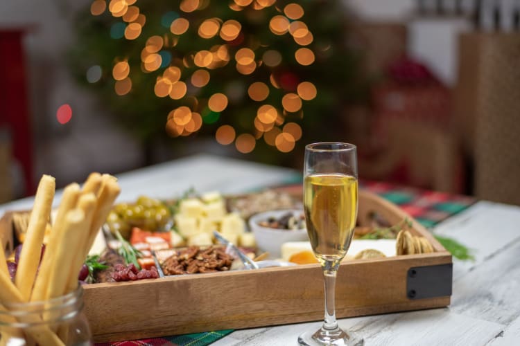 A festive charcuterie board with a glass of prosecco.