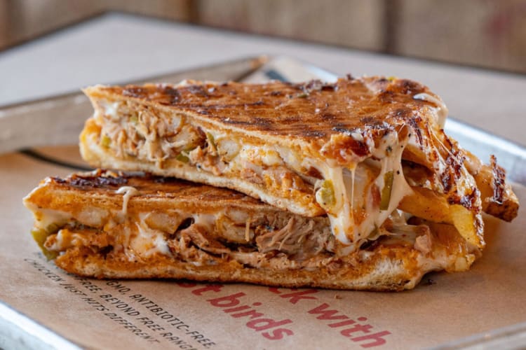 a chicken sandwich with cheese sauce