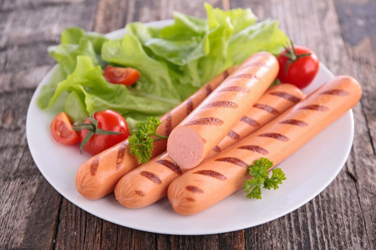 Sausages on a plate with salad.