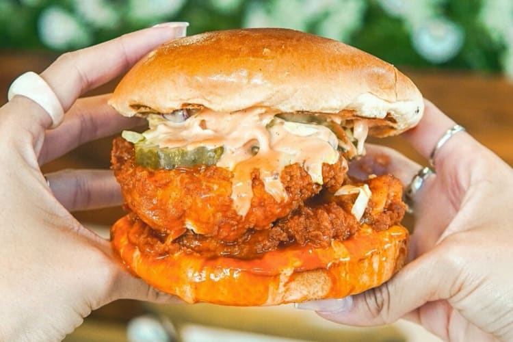Hands holding a chicken burger from 3 Little Chicks in Las Vegas