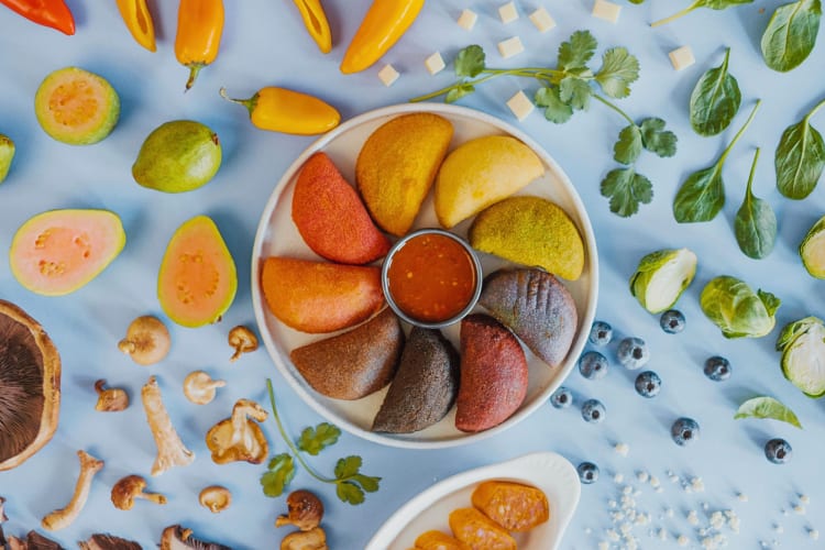 Empanadas on a plate surrounded by vegetables from Nadas in NYC