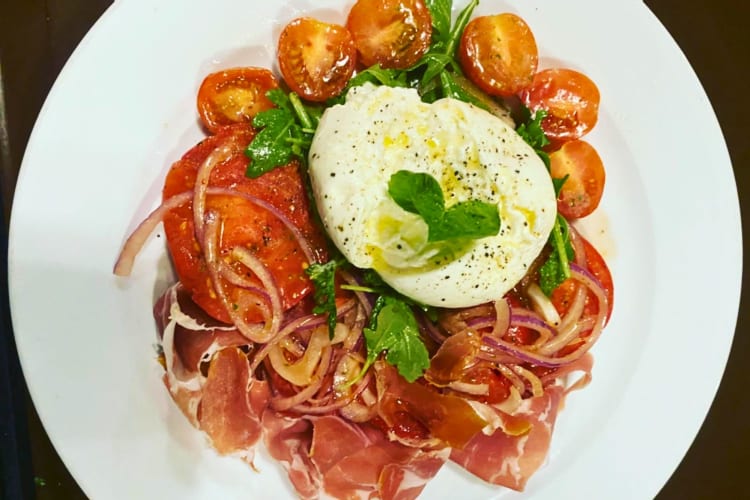 A plate of burrata with heirloom tomatoes.
