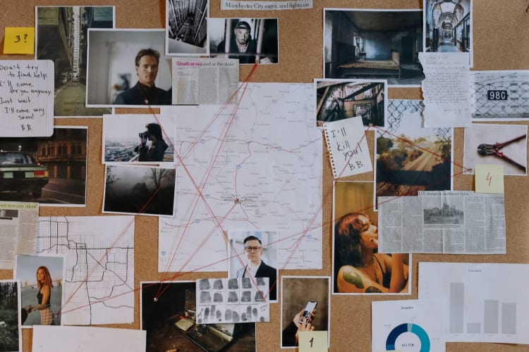 a police board with evidence pinned to it and red string linking pieces together