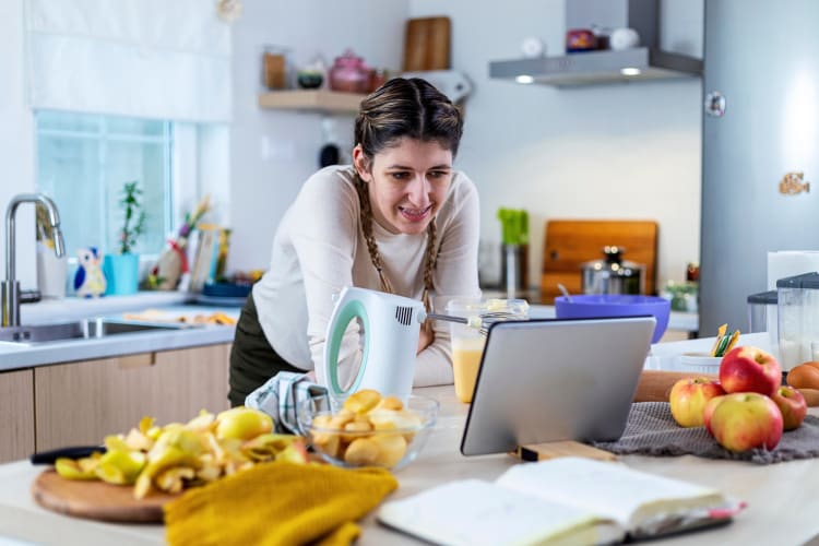 A woman looking at her tablet while taking an online cooking class