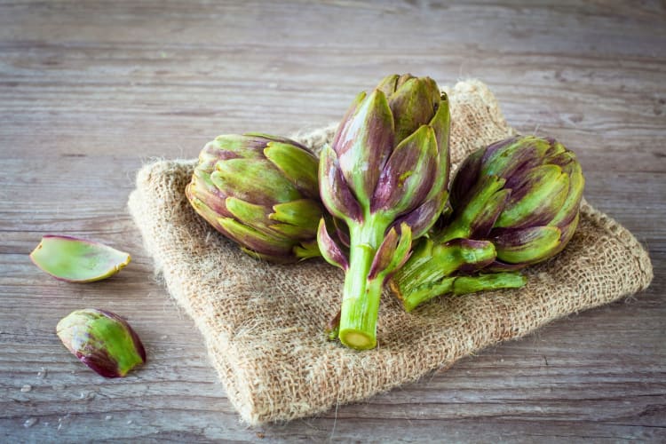 Artichokes on a cutting board.