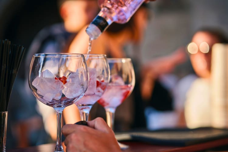 Three gin cocktails being made.