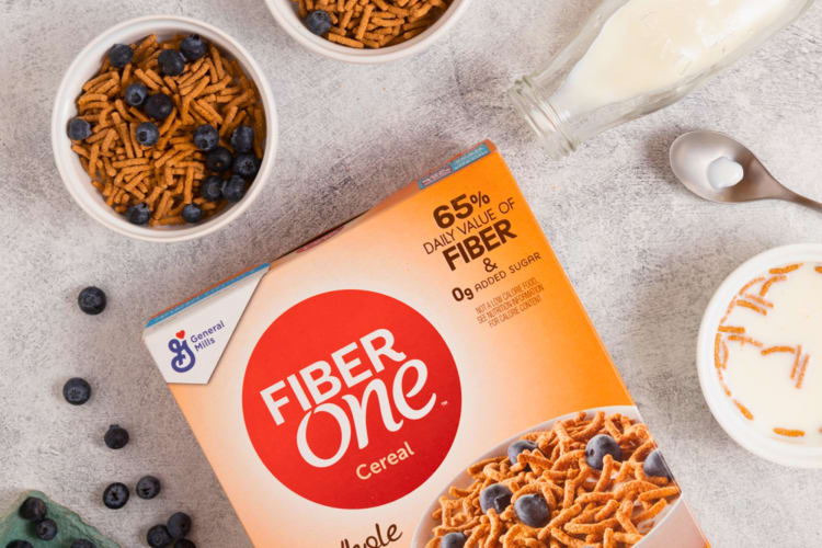 Some bowls of bran cereal next to a FiberOne box.