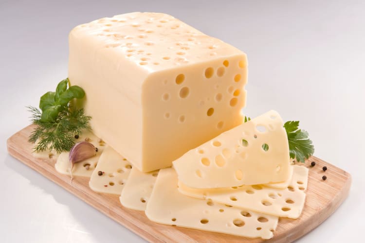 Swiss cheese on a board.
