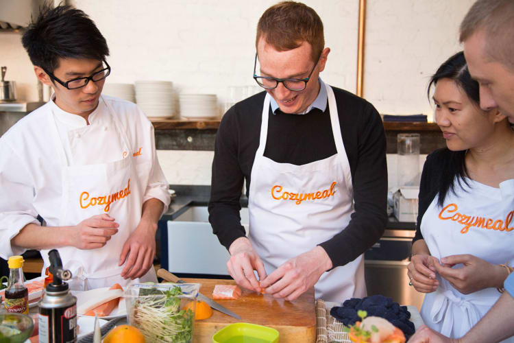 Three people taking a cooking class with a professional chef