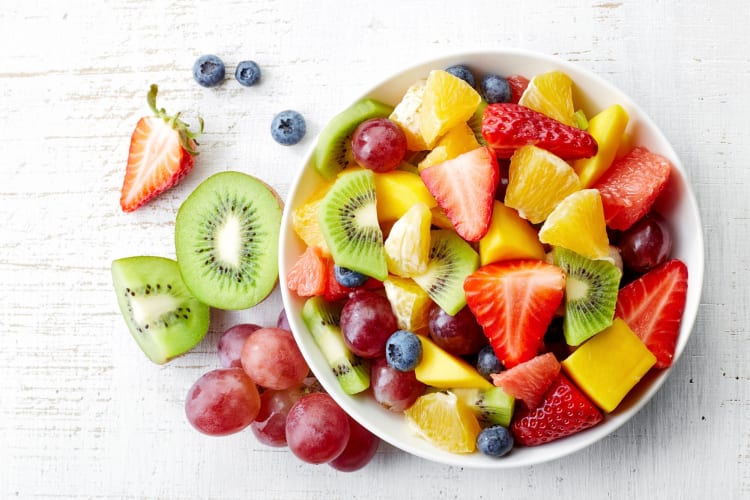A bowl of fruit salad on a table.