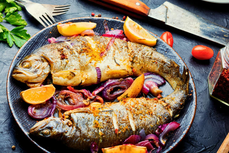 Roasted rainbow trout with lemon and onion.