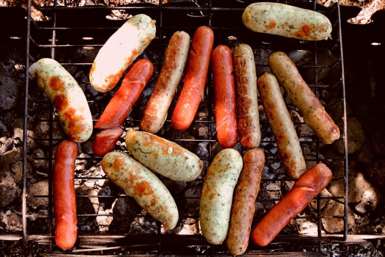 Grilled frankfurter and sausage on the barbecue over coals.