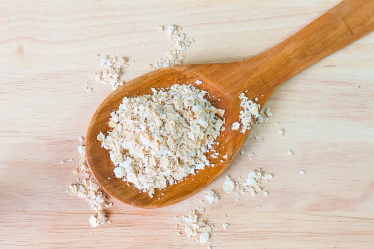 A wooden spoon with instant oatmeal on.