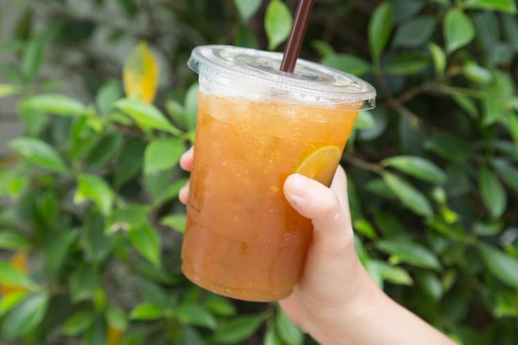 Unsweetened iced tea served with lemon on a to-go cup