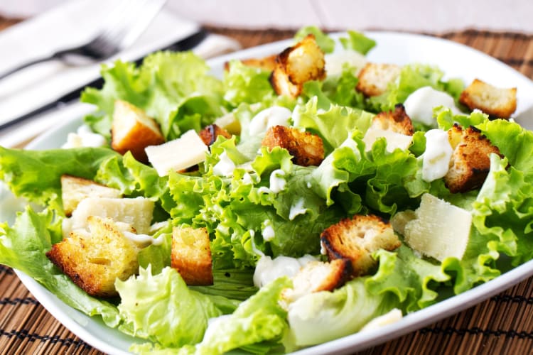 Caesar Salad on a white plate on a table.