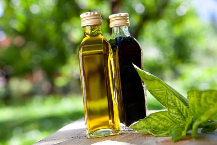A bottle each of olive oil and balsamic vinegar outside.