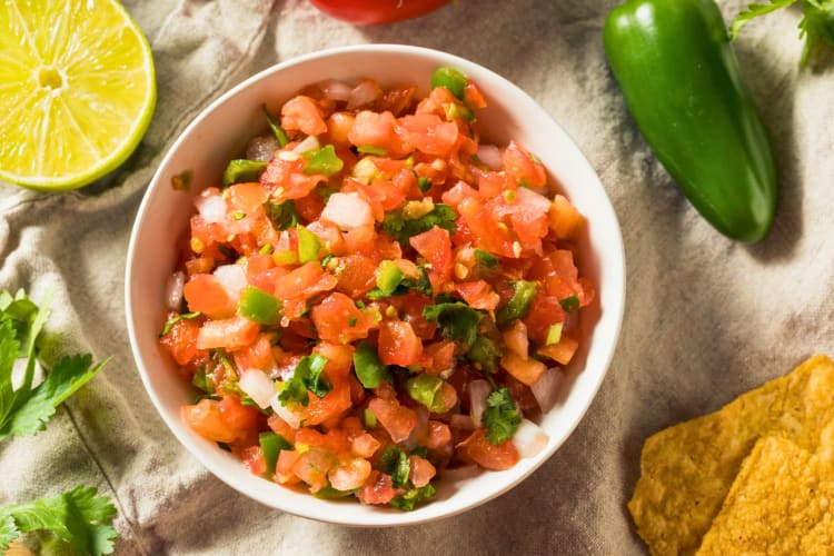 Bowl of pico de gallo salsa on a tableвЃ .