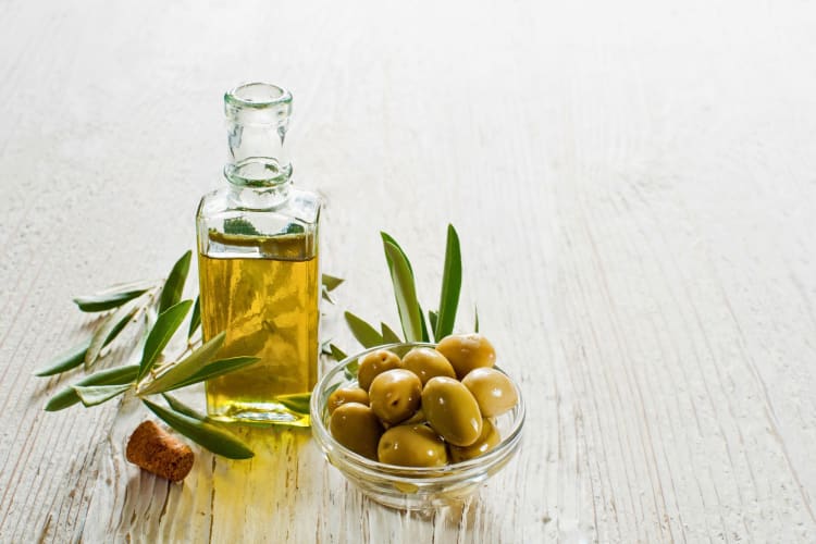 A bowl of olives with oil.