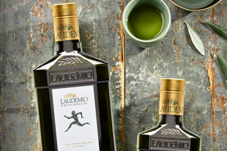 Two bottles of olive oil on a table.