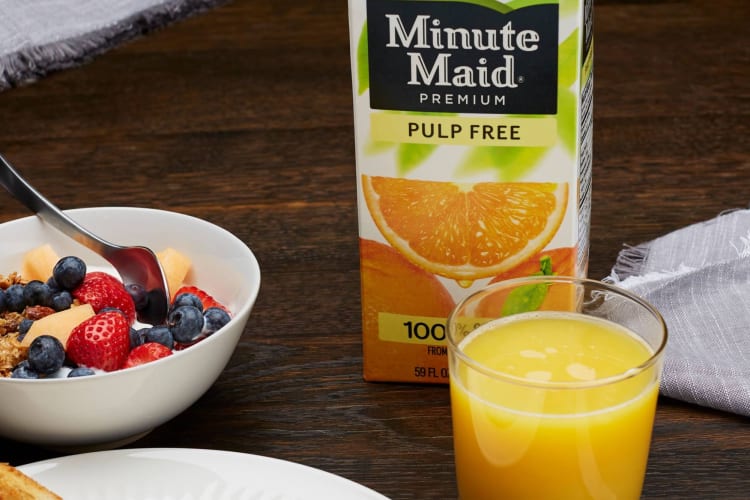 A breakfast bowl with a glass of orange juice.