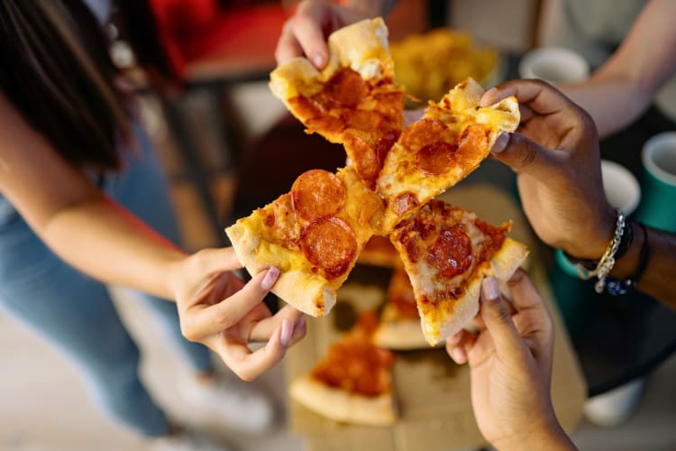 People holding pizza slices.