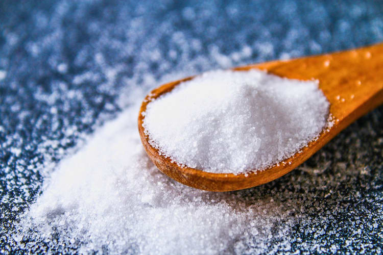 Table salt on a wooden spoon.