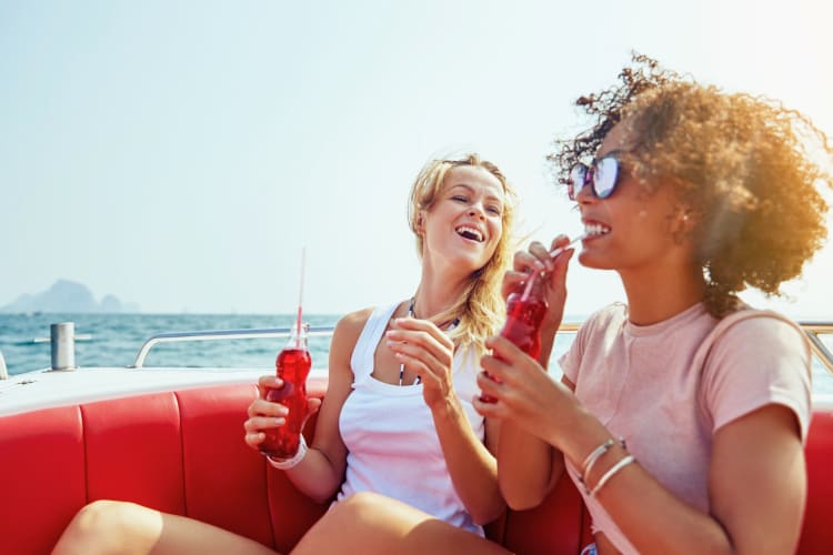 Two women drinking soda on a boat.