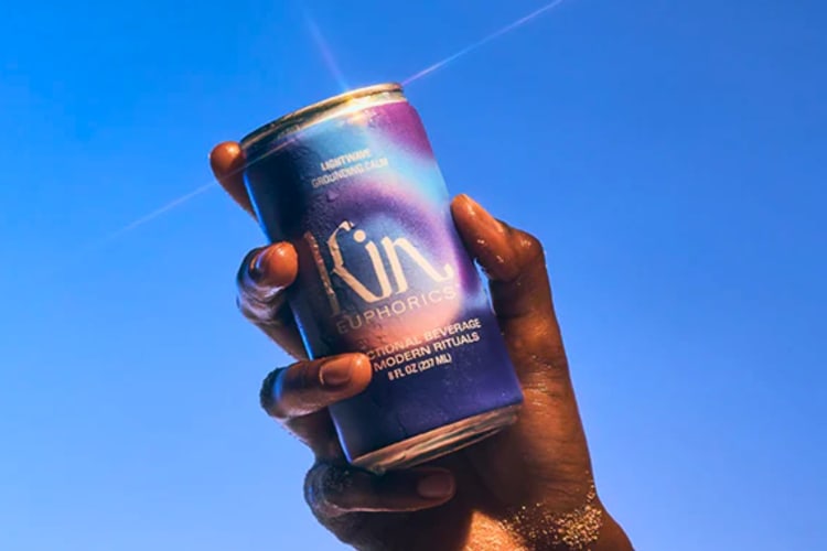 A hand holding a can of non-alcoholic, non-caffeinated soda.