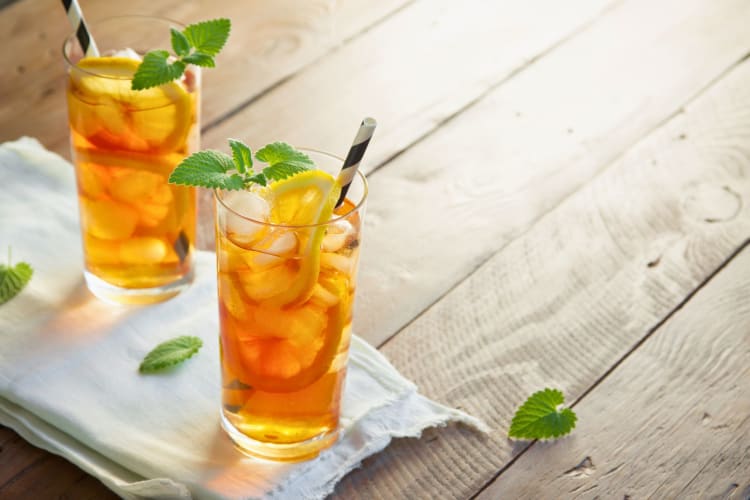 Two glasses of iced tea with lemon.
