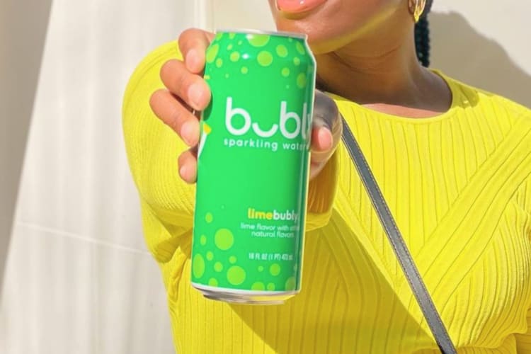 A woman holding a can of Bubly lime.