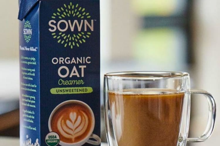 Two coffee creamer containers next to an iced coffee drink