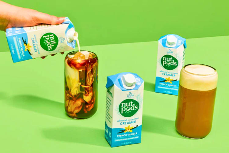 A bottle of coffee creamer next to iced coffees.