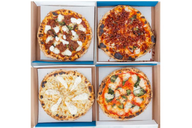 Some pizzas in delivery boxes.