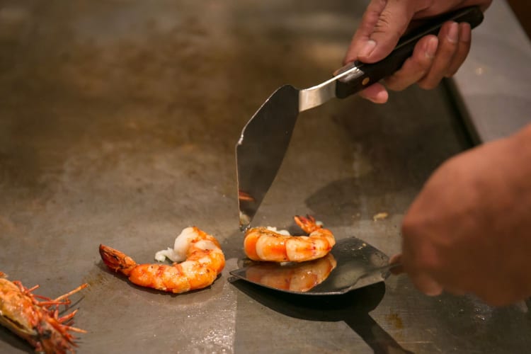 Shrimp being cooked on a hibachi grill.