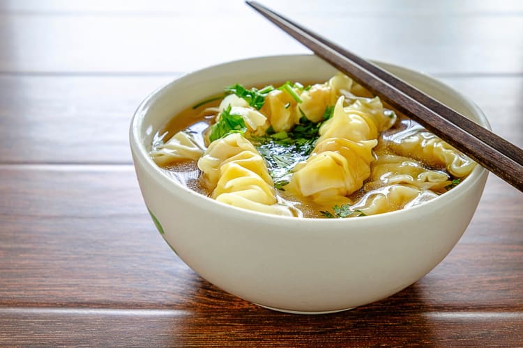 Chopsticks on top of a bowl of wonton noodle soup, a popular Hong Kong food