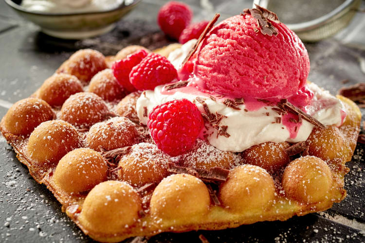 Egg waffle topped with ice cream and raspberries — a tasty Hong Kong food