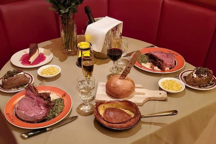 An assortment of House of Prime Rib meals and drinks on a table
