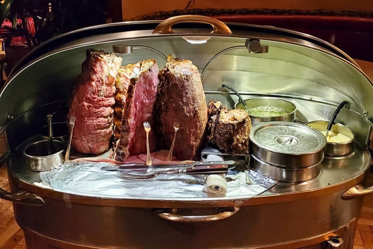 A House of Prime Rib serving tray with meat, sides and cutlery