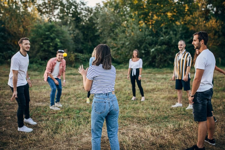 A team of eight throwing a ball around during an ice breaker game