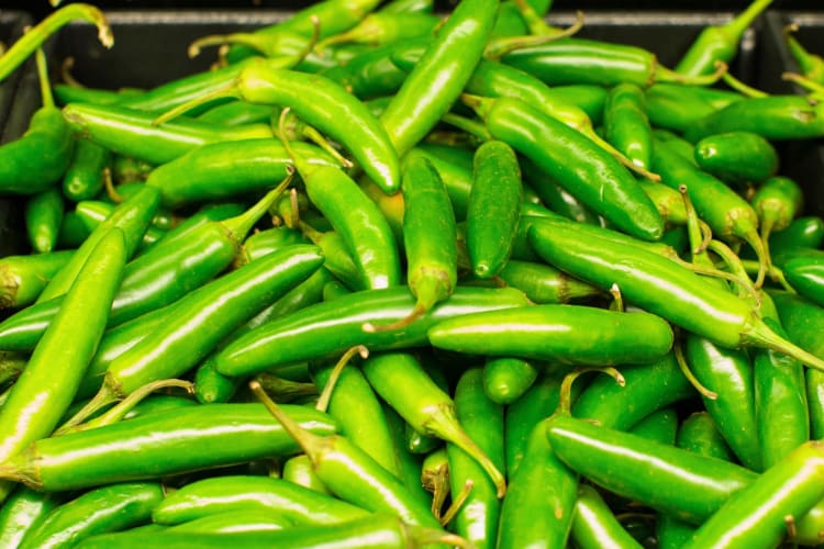 Jalapeno peppers on a wooden board.