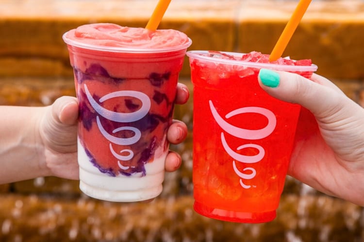 Two hands clinking two different Jamba Juice drinks together