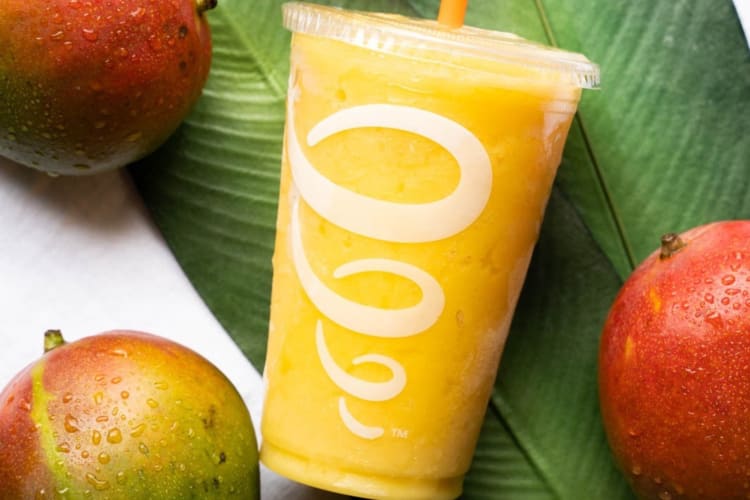 Mango smoothie with some whole mangoes